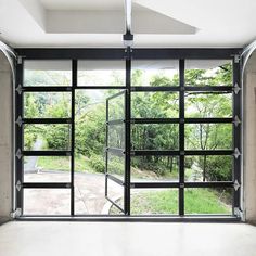 an empty room with glass doors and trees outside