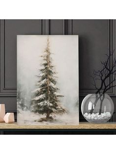 a white christmas tree in a glass vase on a table next to a black and white wall