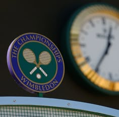 there are two clocks in the background and one has a logo on it, while the other is holding a tennis racket