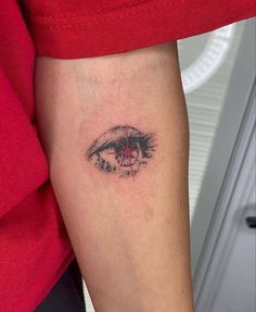 a close up of a person's arm with an eye tattoo on the side