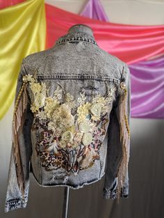 a denim jacket with flowers and feathers on it