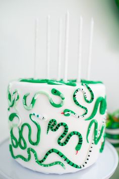 a green and white snake cake on a plate