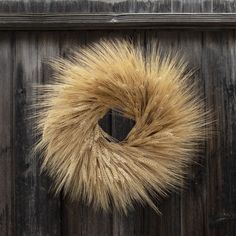 a furry wreath hanging on the side of a wooden door with an animal's fur