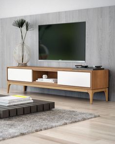 a flat screen tv sitting on top of a wooden entertainment center in a living room