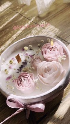 pink roses in a round metal container on a wooden table