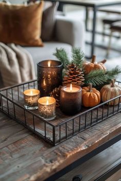 a tray with candles and pine cones on it