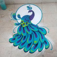 a peacock painted on the ground with blue and green feathers