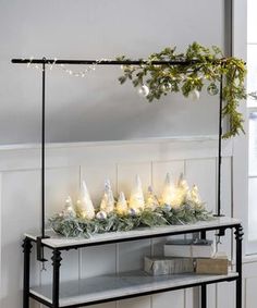 a shelf with christmas lights and garland on it