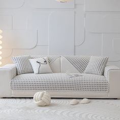 a white couch sitting on top of a rug next to a lamp