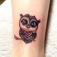 an owl with big eyes and a heart tattoo on the leg is shown in black ink