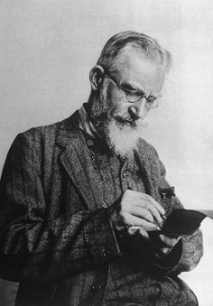 an old black and white photo of a man with a long beard reading a book