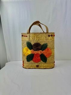 "Retro-style straw beach bag is made of woven straw strands and raffia stitched flowers. The bag is 15\" tall with a 6\" handle and is 14\" wide.  Base is 8.5\" wide.   There is some staining and holes inside the lining of the bag. Please see photos. And handles are a bit frayed. Otherwise, in very good vintage condition.  Would be a great beach bag, or could be displayed as art or used as storage for towels, blankets, etc. This shop uses recycled shipping materials in order to limit shipping costs and reduce waste." Raffia Flowers, Storage For Towels, Flowers Bucket, Stitched Flowers, Straw Beach Bag, Flower Bucket, Reduce Waste, Woven Bag, Retro Stil