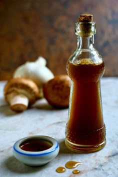 a glass bottle filled with liquid next to garlic