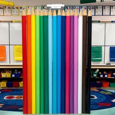 there are many different colored pencils lined up in a row on the floor next to each other