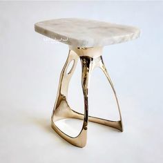 a white marble topped table with gold legs