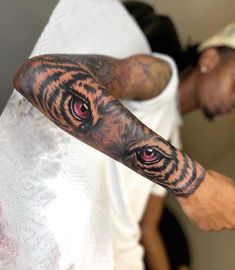 a man's arm with a tiger tattoo on it and red eyes in the center