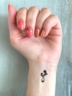 a woman's hand with a small tattoo on her wrist and the word love