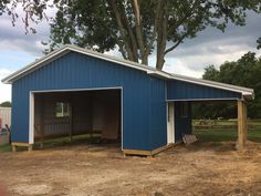 a blue barn with two stalls and a tree in the background