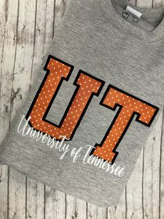 a gray t - shirt with the letters ut on it