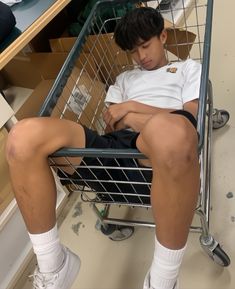 a man sitting in a shopping cart with his legs crossed