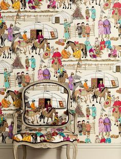 a wallpapered room with horses and people on the wall next to a chair