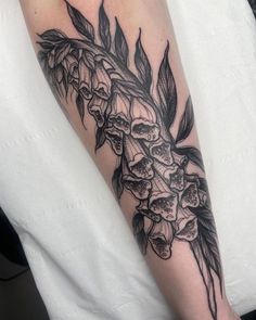 a black and white tattoo with flowers on the arm