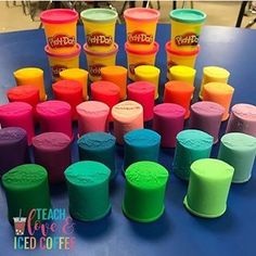 there are many different colored cups on the table