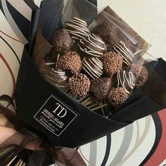 chocolate covered candies in a black paper bag