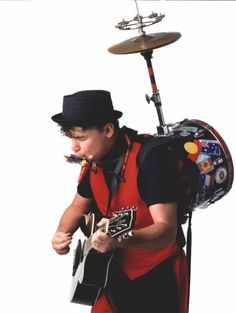 a man with a hat and guitar in front of a musical instrument on a white background