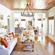 a living room filled with furniture and a chandelier hanging over the top of it