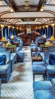 the inside of a train car with blue couches and chairs on it's sides