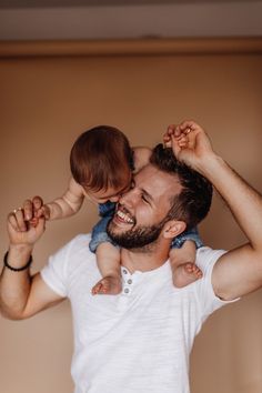 a man holding a small child on his shoulders