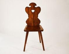 a wooden chair with a heart cut out on the back