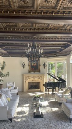 a living room filled with furniture and a chandelier above a fire place in front of a piano