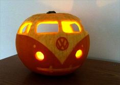 a carved pumpkin with a vw bus on it's face and lights in the eyes