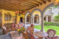 an outdoor patio with chairs and tables in the center, surrounded by stone archways