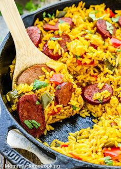 a skillet filled with yellow rice and sausage