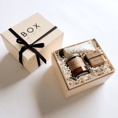 the box is open and has two items in it, including an empty candle and soap