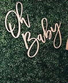 there is a sign that says oh baby on the side of a green carpeted wall