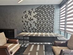 a living room filled with furniture and a wall mounted metal art piece on the wall