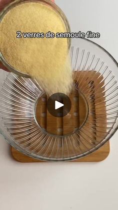 a person is pouring something into a glass bowl with a wooden base and bamboo stand