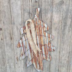 an old rusty leaf hanging on a wooden fence