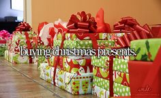 many wrapped presents are sitting on the floor in front of a wall with words saying buying christmas presents