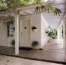 a white house with potted plants on the porch