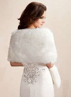 a woman in a white dress is wearing a fur stole with beading on it