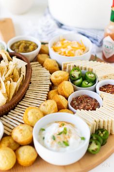 a platter filled with chips, dips and condiments on a table