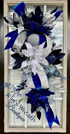 a blue and white christmas wreath hanging in front of a window