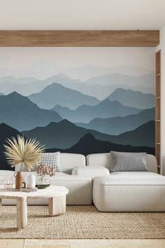 a living room with mountains painted on the wall and coffee table in front of it