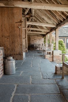 an outdoor area with benches, tables and buckets on the side of the building