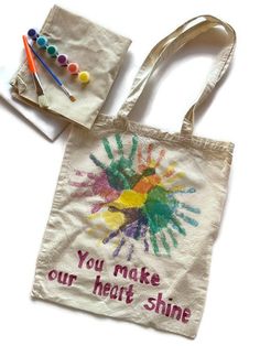 a tote bag with the words you make our heart shine painted on it next to some crayons